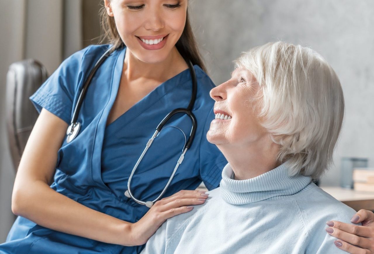 vertical-portrait-of-happy-elderly-woman-with-nurse-at-home.jpg